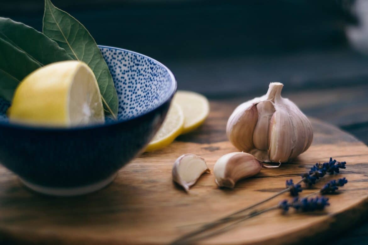 lemon slice and leaves in bowl beside garlic